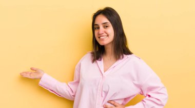 Genç İspanyol kadın kendini mutlu ve neşeli hissediyor, gülümsüyor ve seni hoş karşılıyor, seni dostça bir jestle içeri davet ediyor.