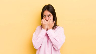 Genç İspanyol kadın endişeli, stresli ve korkmuş görünüyor, tırnaklarını yiyor ve yanal fotokopi için yer arıyor.