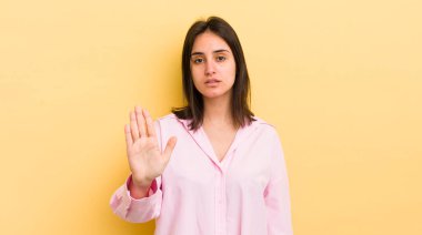 Genç İspanyol kadın ciddi, sert, hoşnutsuz ve kızgın görünüyor. Avuç içinin açık olması jesti durduruyor.