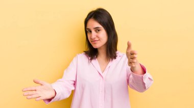 Genç İspanyol kadın neşeyle gülümsüyor sıcak, dostça, sevgi dolu bir kucak veriyor, mutlu ve sevimli hissediyor.