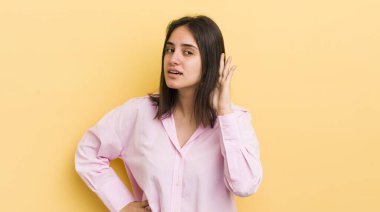 Genç İspanyol kadın gülümsüyor, tuhaf bir şekilde yan tarafa bakıyor, bir dedikoduyu dinlemeye ya da bir sırrı duymaya çalışıyor.