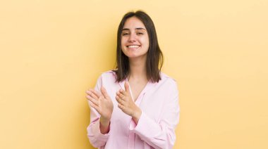 Genç İspanyol kadın mutlu ve başarılı hissediyor, gülümsüyor ve alkışlıyor, alkışlarla tebrik ediyor.