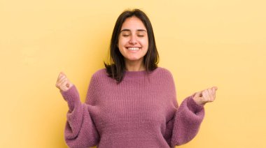 Genç İspanyol kadın son derece mutlu ve şaşırmış görünüyor, başarıyı kutluyor, bağırıyor ve zıplıyor.