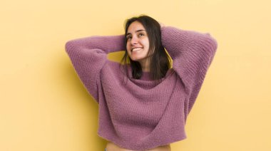 Genç İspanyol kadın gülümsüyor ve rahatlıyor, tatmin oluyor ve kaygısızca gülüyor.