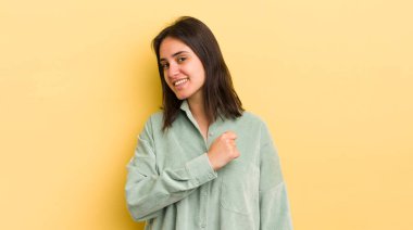 Genç İspanyol kadın mutlu, pozitif ve başarılı hissediyor, meydan okumayla karşılaştığında motive oluyor veya iyi sonuçları kutluyor.