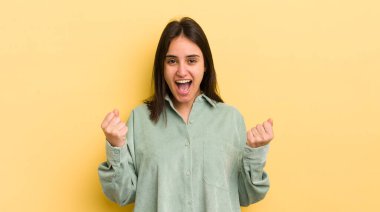 Genç İspanyol kadın zaferle bağırıyor, gülüyor, mutlu ve heyecanlı hissediyor başarıyı kutlarken.