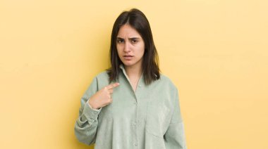 Genç İspanyol kadın şaşkın, şaşkın ve güvensiz hissediyor, kendini gösterip kim olduğunu soruyor, ben mi??