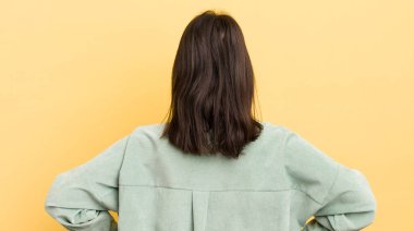 Genç İspanyol kadın kafası karışık ya da dolu ya da şüphe ve soru dolu, merak ediyor, elleri kalçasında, dikiz aynasından