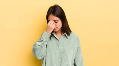 Genç İspanyol kadın stresli, mutsuz ve hayal kırıklığına uğramış, alınına dokunmuş ve şiddetli baş ağrısı çeken.