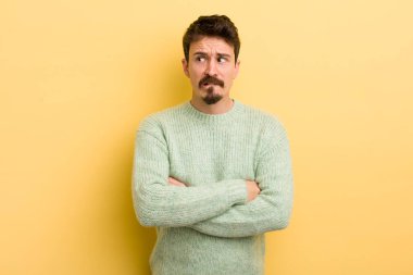 Genç İspanyol adam şüphe ediyor ya da düşünüyor, dudağını ısırıyor ve kendini güvensiz ve gergin hissediyor, kenarda yer arıyor.