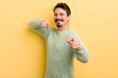 Genç İspanyol adam mutlu ve kendinden emin hissediyor, kamerayı iki eliyle gösteriyor ve gülüyor, seni seçiyor.