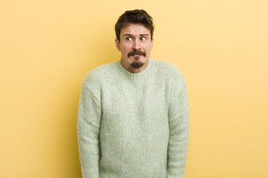 Genç İspanyol adam endişeli, stresli, endişeli ve korkmuş görünüyor, panikliyor ve dişlerini sıkıyor.