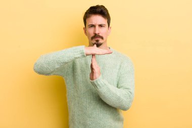 Genç İspanyol adam ciddi, sert, kızgın ve canı sıkkın görünüyor.