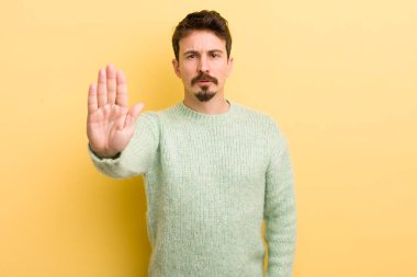 Genç İspanyol adam ciddi, sert, hoşnutsuz ve kızgın görünüyor.