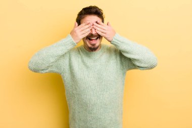 Genç İspanyol adam gülümsüyor ve mutlu hissediyor, iki eliyle gözlerini kapatıyor ve inanılmaz bir sürpriz bekliyor.