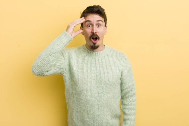 Genç İspanyol adam mutlu, şaşkın ve şaşırmış görünüyor, gülümsüyor ve inanılmaz ve inanılmaz iyi haberleri fark ediyor.