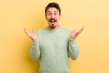 Genç İspanyol adam mutlu, heyecanlı, şaşırmış ya da şok olmuş hissediyor. İnanılmaz bir şeye gülümsüyor ve hayrete düşüyor.