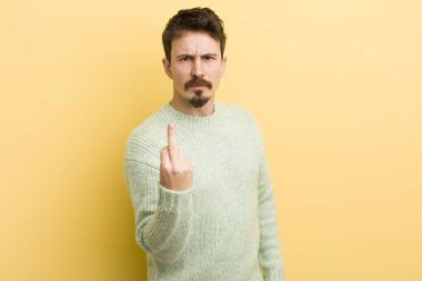 Genç İspanyol bir adam kızgın, sinirli, asi ve agresif hissediyor, orta parmağını sallıyor, karşı koyuyor.