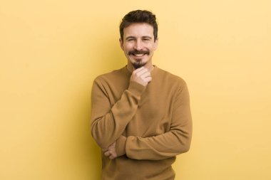 Genç İspanyol adam gülümsüyor, hayattan zevk alıyor, mutlu, arkadaş canlısı, tatmin olmuş ve tasasız.