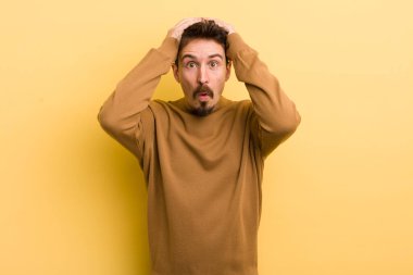 Genç İspanyol adam heyecanlı ve şaşırmış görünüyor, ağzı açık, iki eli de başında, kendini şanslı hissediyor.