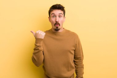 Genç İspanyol adam inançsızlıktan şaşkın şaşkın bakıyor, yan taraftaki objeyi işaret ediyor ve diyor ki: