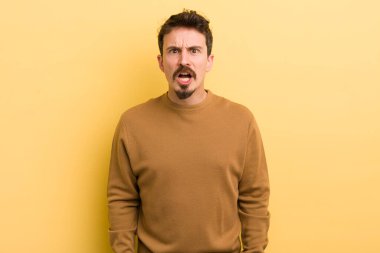 Şok olmuş, kızgın, sinirli ya da hayal kırıklığına uğramış, ağzı açık ve öfkeli görünen genç bir İspanyol.