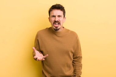 Genç İspanyol bir adam sinirli, sinirli ve sinirli görünüyor. Senin neyin var? 