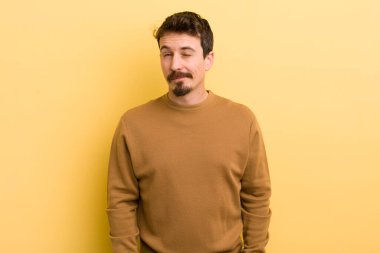 Genç İspanyol adam mutlu ve arkadaş canlısı görünüyor, gülümsüyor ve pozitif bir tavırla sana göz kırpıyor.