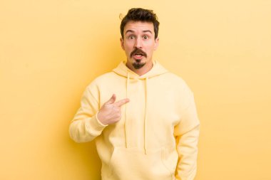 Şok olmuş ve ağzı açık, kendini işaret eden genç İspanyol bir adam.