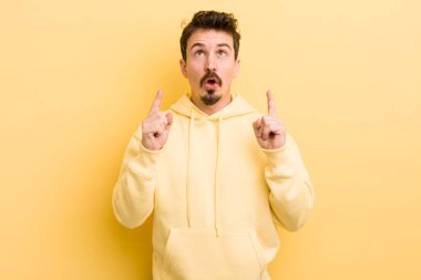 Genç İspanyol bir adam şaşkınlık içinde ve ağzı açık. Şok olmuş ve şaşırmış bir bakışla yukarı bakıyor.