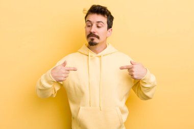 Genç İspanyol adam gururlu, pozitif ve iki eliyle göğsünü gösteren