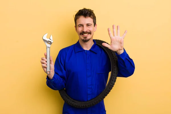 Mann Lächelt Und Sieht Freundlich Aus Zeigt Nummer Fünf Fahrradwerkstatt — Stockfoto