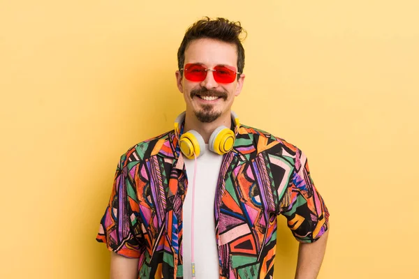 Mutlu bir şekilde gülümsüyor, eli kalçasında ve kendinden emin bir şekilde. müzik konseptini dinlemek