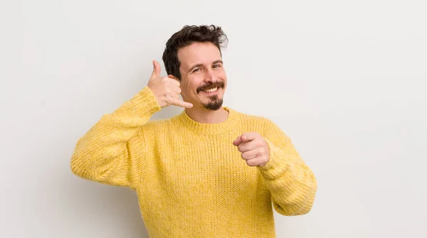 Hispanic Young Man Smiling Cheerfully Pointing Camera While Making Call — Stock Photo, Image