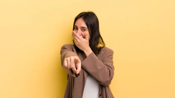 young hispanic woman laughing at you, pointing to camera and making fun of or mocking you