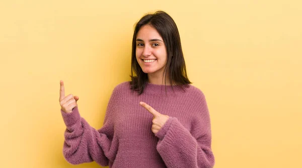 コピースペースに物を見せる両手で楽しそうに笑顔で上を向いている若いヒスパニック系の女性 — ストック写真