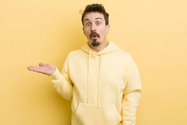 Young Hispanic Man Looking Surprised Shocked Jaw Dropped Holding Object — Stok fotoğraf