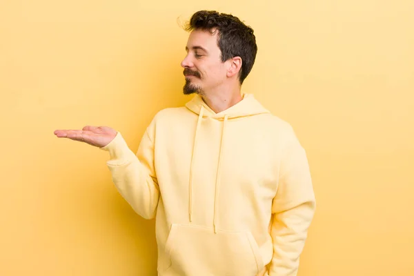 Joven Hispano Sintiéndose Feliz Sonriendo Casualmente Mirando Objeto Concepto Sostenido — Foto de Stock