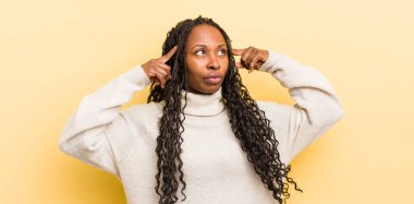 Siyah, güzel bir kadın, kafası karışık ya da şüpheci, bir fikre odaklanmış, çok düşünüyor, kenarda boşluğu kopyalamak istiyor.