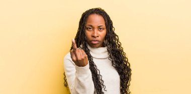 Siyah güzel kadın kızgın, sinirli, asi ve agresif hissediyor, orta parmağını sallıyor, karşı koyuyor.