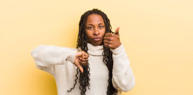 Siyah güzel kadın kafası karışık, bilgisiz ve kararsız hissediyor, iyi ve kötü seçenekleri farklı seçeneklerde tartıyor.