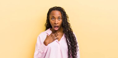 Siyah güzel kadın şaşkın, şaşkın ve şaşırmış hissediyor, elleri göğsünde ve ağzı açık, kim olduğunu söylüyor, ben mi??