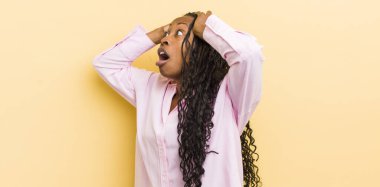 Korkunç bir hata yüzünden dehşete düşmüş ve şok olmuş görünen ağzı açık, siyah, güzel bir kadın, el ele tutuşuyor.