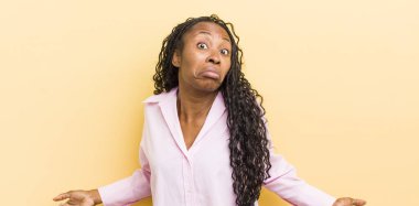 black pretty woman feeling clueless and confused, having no idea, absolutely puzzled with a dumb or foolish look