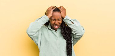 Siyah, güzel bir kadın stresli ve hayal kırıklığına uğramış hissediyor. Yumruk yumruğa, yorgun, mutsuz ve migren ağrısı çekiyor.