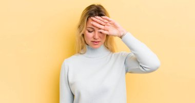 Gergin, yorgun ve hayal kırıklığına uğramış, alnından ter damlayan, umutsuz ve bitkin hisseden sarışın beyaz kadın.