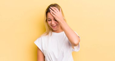 Sarışın, beyaz kadın gülüyor ve alnına şaplak atıyor. Unuttum ya da aptalca bir hataydı. 