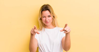 Sarışın, beyaz bir kadın kamerayı iki parmağıyla ve kızgın bir ifadeyle sana görevini yapmanı söylüyor.