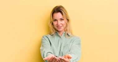Sarışın, beyaz kadın güler yüzlü, arkadaş canlısı, kendine güvenen, olumlu bakışlı, bir nesne ya da konsept sunan ve gösteren
