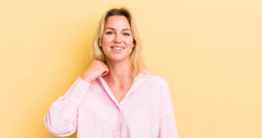 Sarışın, beyaz bir kadın neşeli ve kendinden emin bir şekilde gülüyor.